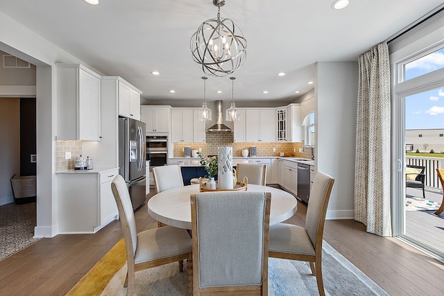 dining area with hardwood / wood-style flooring, sink, and an inviting chandelier