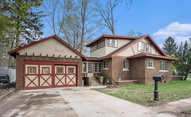 633 Marshall St, Allegan, MI 49010 - tudor-style house with brick siding, a front lawn, a garage, stucco siding, and concrete driveway