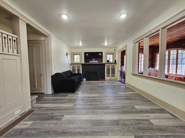 633 Marshall St, Allegan, MI 49010 - living room with crown molding, wood finished floors, a brick fireplace, baseboards, and recessed lighting