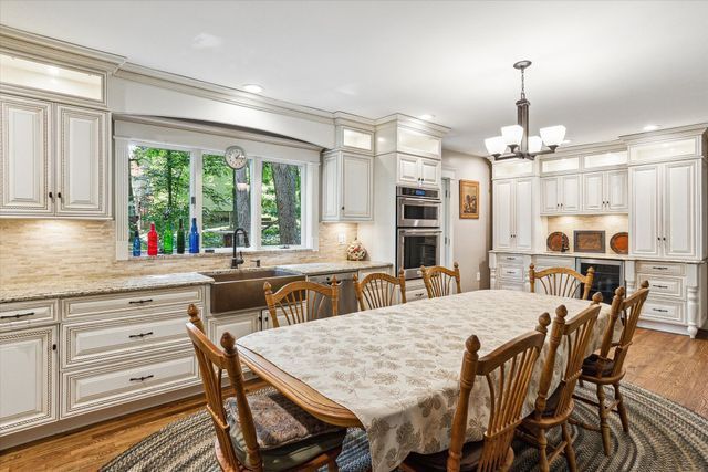 dining room featuring sink, beverage cooler, dark hardwood / wood-style floors, crown molding, and a chandelier