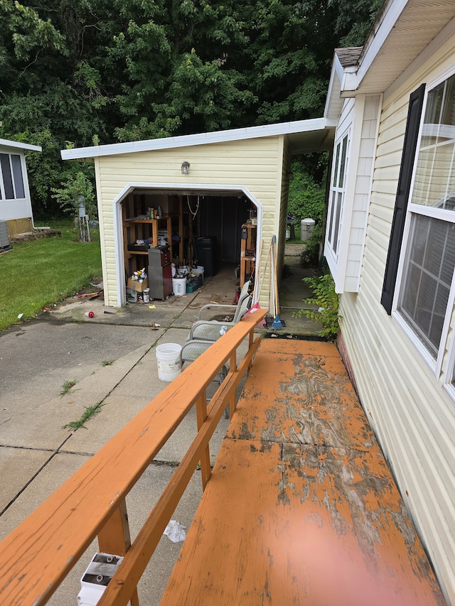 view of patio featuring a garage, an outbuilding, and central AC unit