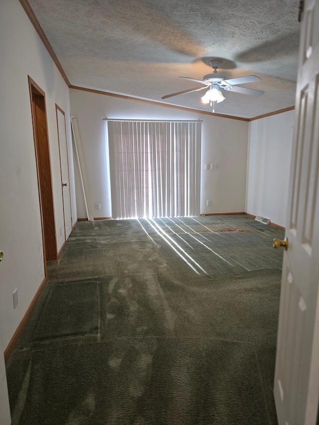 carpeted spare room featuring ceiling fan, a textured ceiling, ornamental molding, and vaulted ceiling