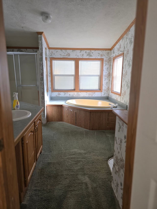 bathroom with vanity, crown molding, a textured ceiling, and shower with separate bathtub