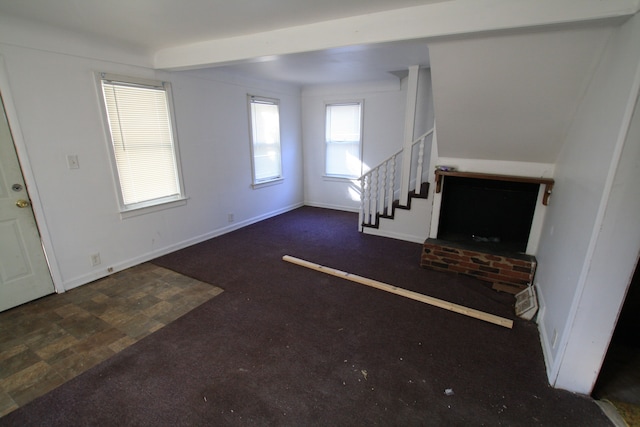 unfurnished living room featuring beamed ceiling