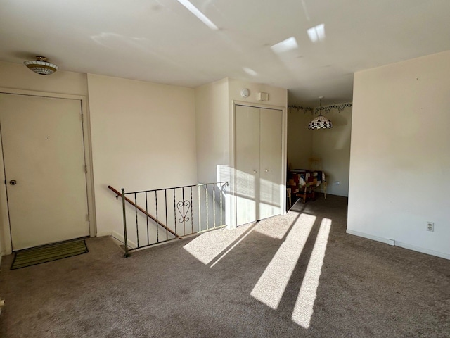 carpeted empty room featuring baseboards