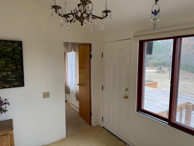 carpeted foyer featuring an inviting chandelier