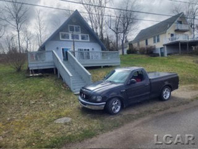 view of front of property featuring stairway and a deck