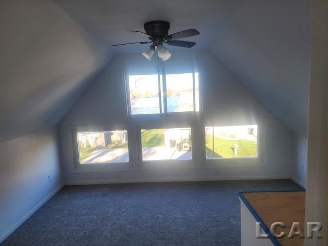 additional living space featuring carpet floors, lofted ceiling, and ceiling fan