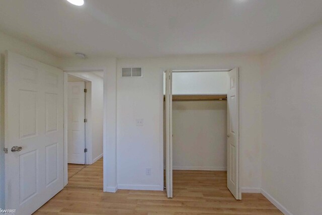 unfurnished bedroom with light hardwood / wood-style floors and a closet