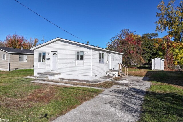 view of front facade with a shed and a front lawn