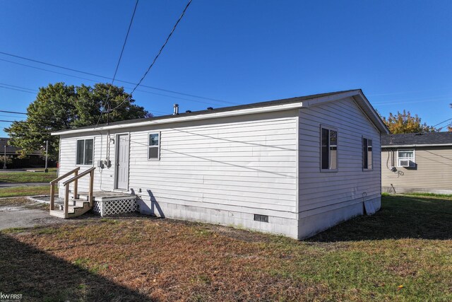 exterior space featuring cooling unit and a front yard