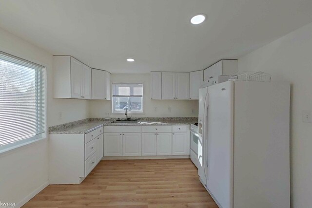 kitchen featuring white cabinets, white appliances, a healthy amount of sunlight, and sink