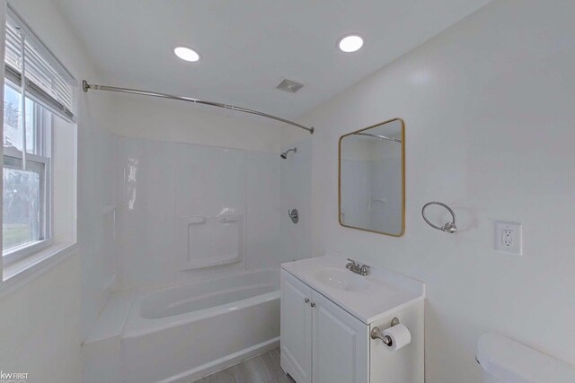 full bathroom with hardwood / wood-style floors, toilet, shower / bathtub combination, and a healthy amount of sunlight