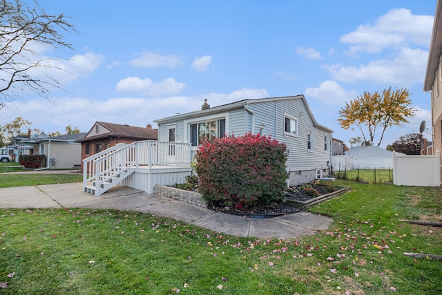 view of front of property with a wooden deck and a front yard