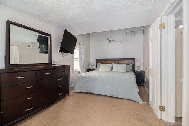 carpeted bedroom with a textured ceiling and ceiling fan