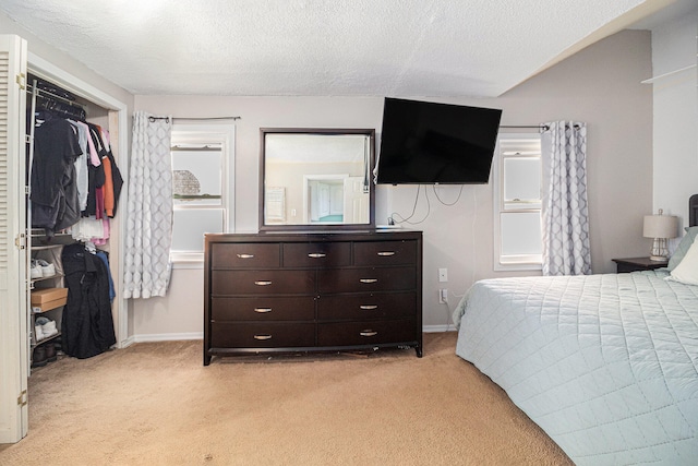 carpeted bedroom with a closet and a textured ceiling