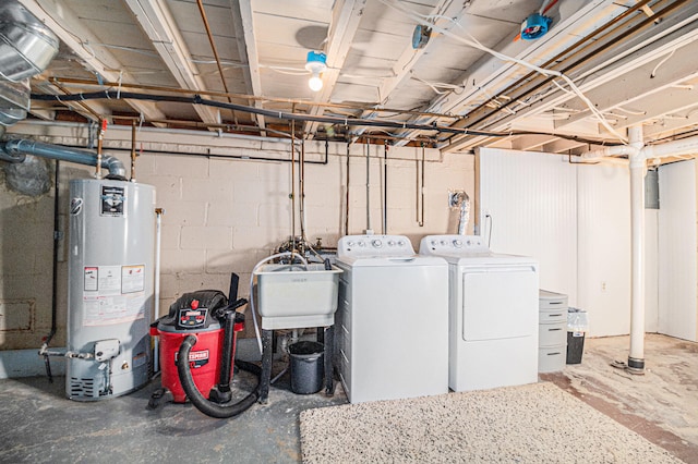 basement featuring separate washer and dryer, sink, and water heater