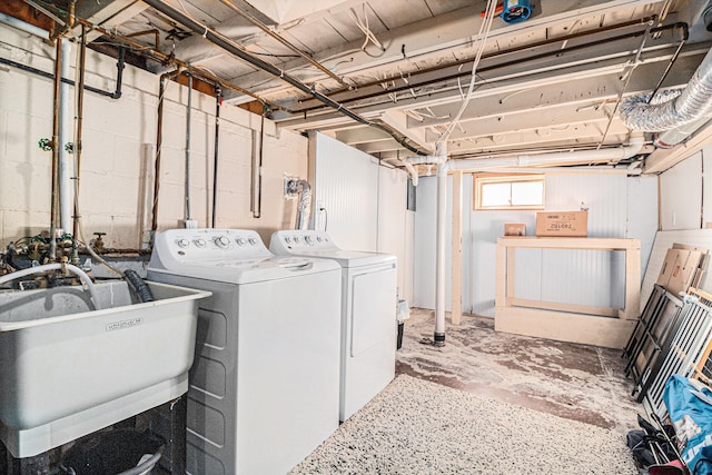 laundry area with separate washer and dryer and sink