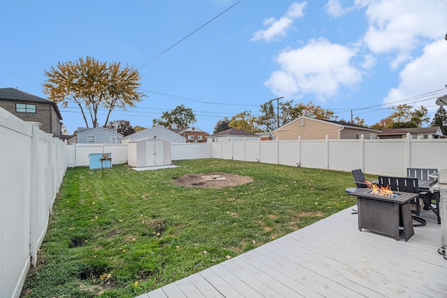 view of yard with a storage shed, a deck, and an outdoor fire pit