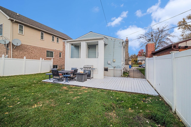 back of property featuring a lawn and a wooden deck