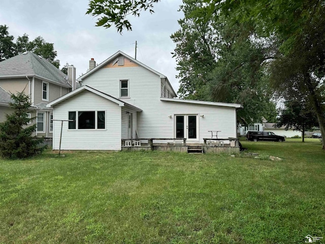 rear view of house with french doors and a lawn