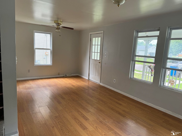 unfurnished room featuring light hardwood / wood-style floors, a wealth of natural light, and ceiling fan