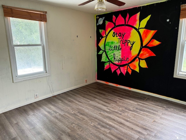 spare room with a healthy amount of sunlight, ceiling fan, and wood-type flooring