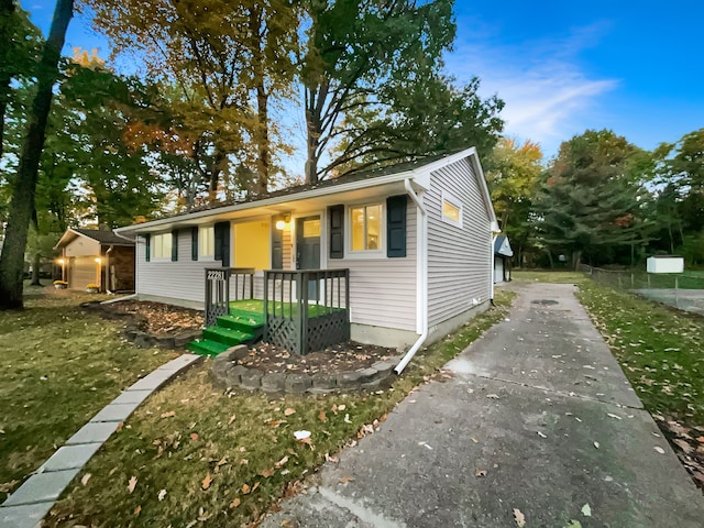 ranch-style home featuring covered porch and a front yard