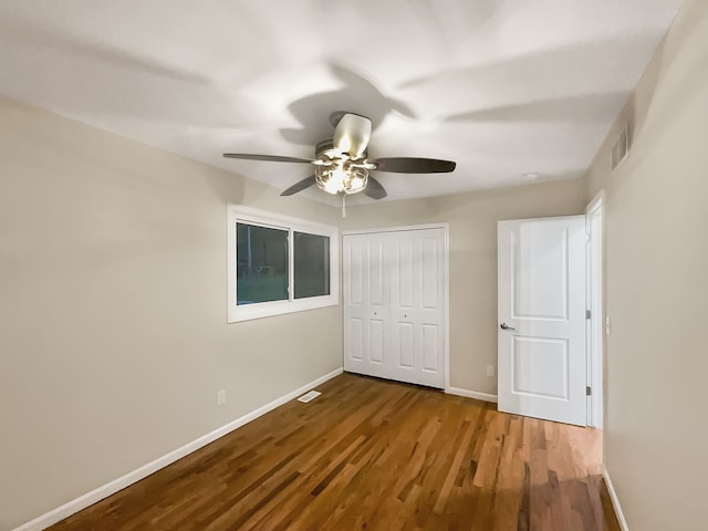 unfurnished bedroom with ceiling fan, a closet, and wood-type flooring