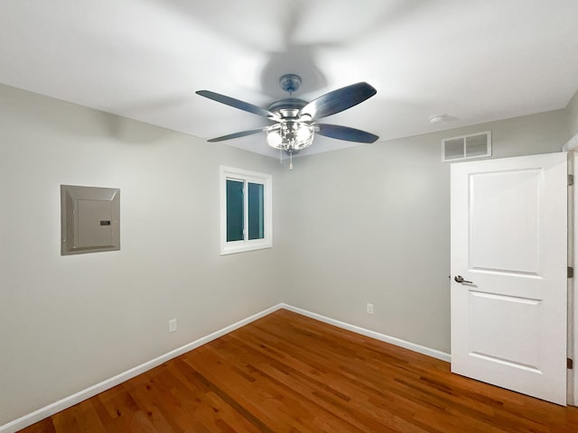 spare room featuring hardwood / wood-style floors, ceiling fan, and electric panel