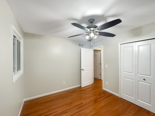 unfurnished bedroom with ceiling fan, a closet, and hardwood / wood-style flooring