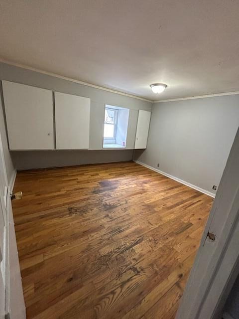 unfurnished room featuring crown molding and hardwood / wood-style floors