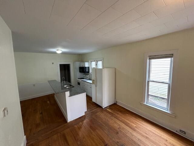 kitchen featuring white appliances, dark hardwood / wood-style flooring, white cabinetry, and sink