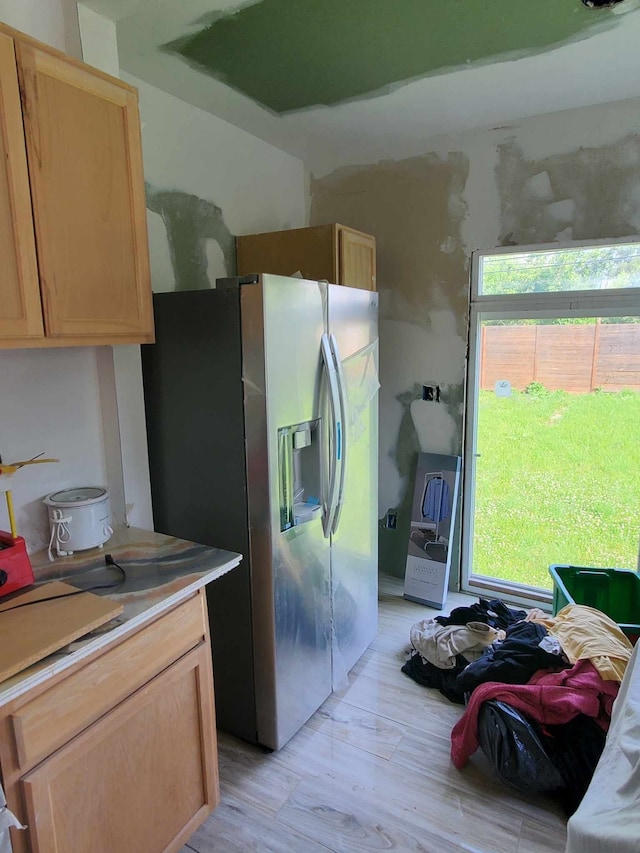 kitchen with a healthy amount of sunlight, light hardwood / wood-style floors, stainless steel refrigerator with ice dispenser, and light brown cabinetry