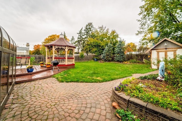 view of yard featuring a gazebo, a storage unit, a deck, and a patio