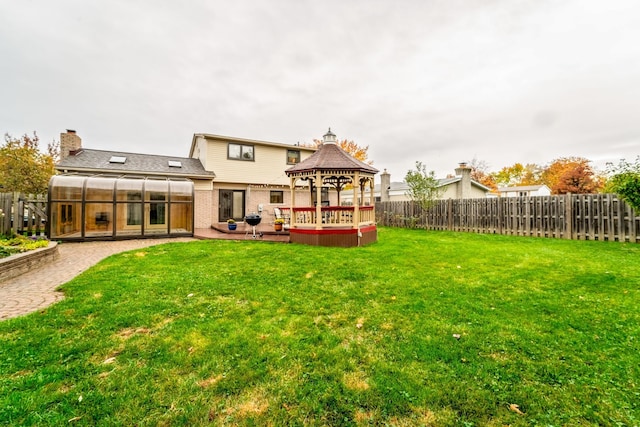 back of house with a gazebo, a sunroom, and a lawn