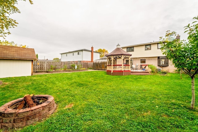 view of yard featuring a gazebo, a shed, and an outdoor fire pit