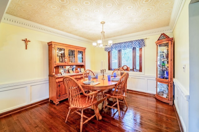 dining space with ornamental molding, dark wood-type flooring, and a chandelier