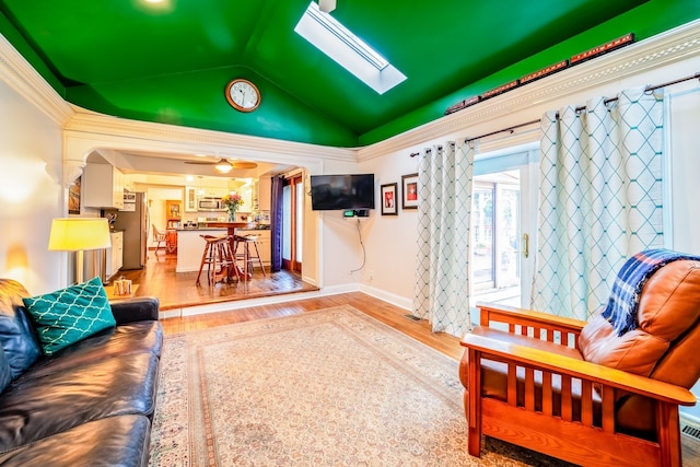 interior space with lofted ceiling with skylight, light hardwood / wood-style flooring, and ceiling fan