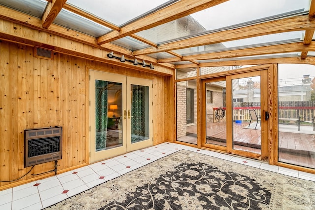 sunroom featuring beamed ceiling, heating unit, and french doors