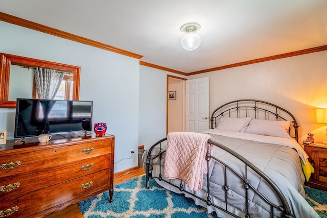 bedroom with hardwood / wood-style floors and ornamental molding