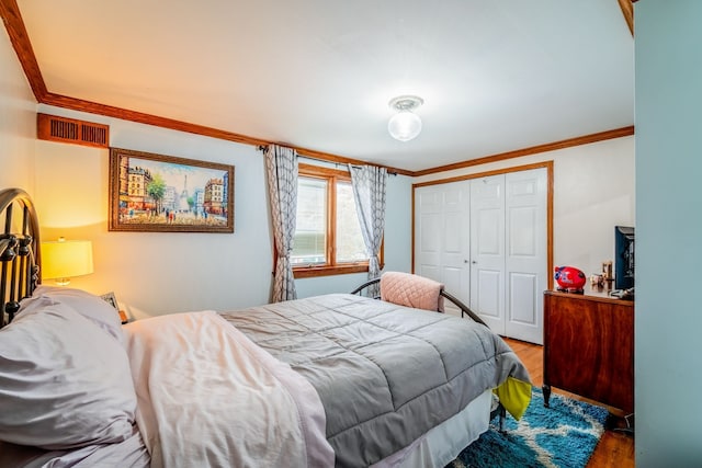 bedroom with light hardwood / wood-style floors, a closet, and crown molding