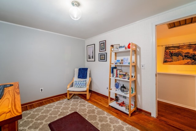 living area featuring hardwood / wood-style flooring and ornamental molding