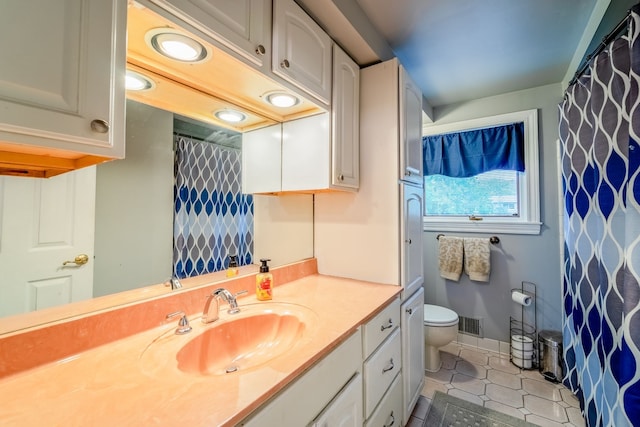 bathroom featuring tile patterned flooring, vanity, and toilet