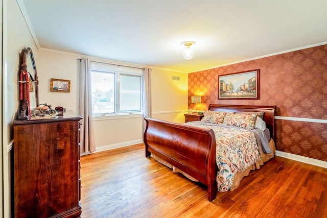 bedroom with hardwood / wood-style floors and ornamental molding