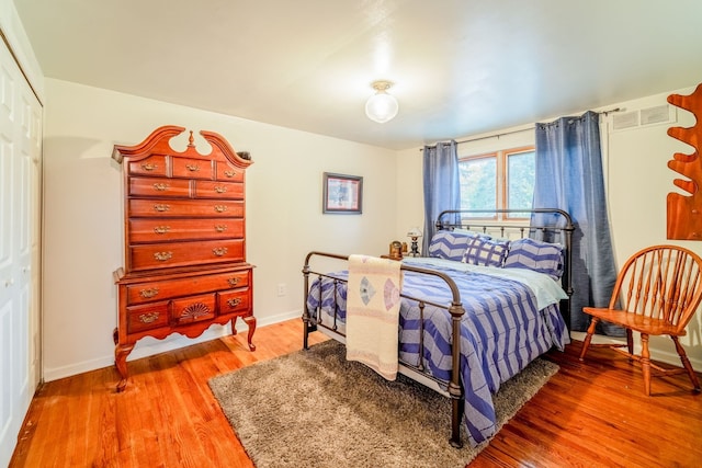 bedroom with wood-type flooring and a closet