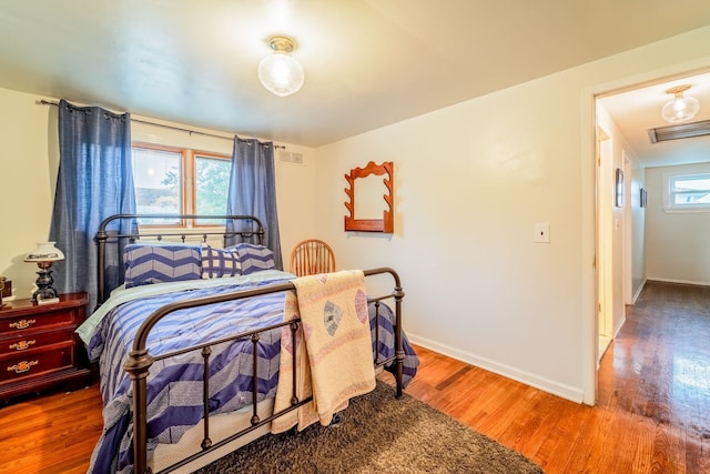 bedroom featuring hardwood / wood-style floors and multiple windows