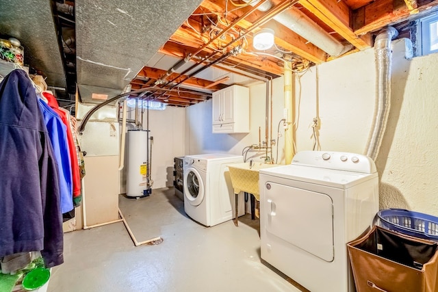 laundry room with washer and clothes dryer, cabinets, and water heater