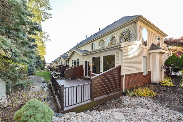 rear view of property featuring a wooden deck