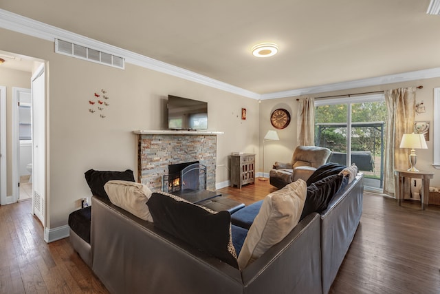 living room with crown molding, a stone fireplace, and dark wood-type flooring